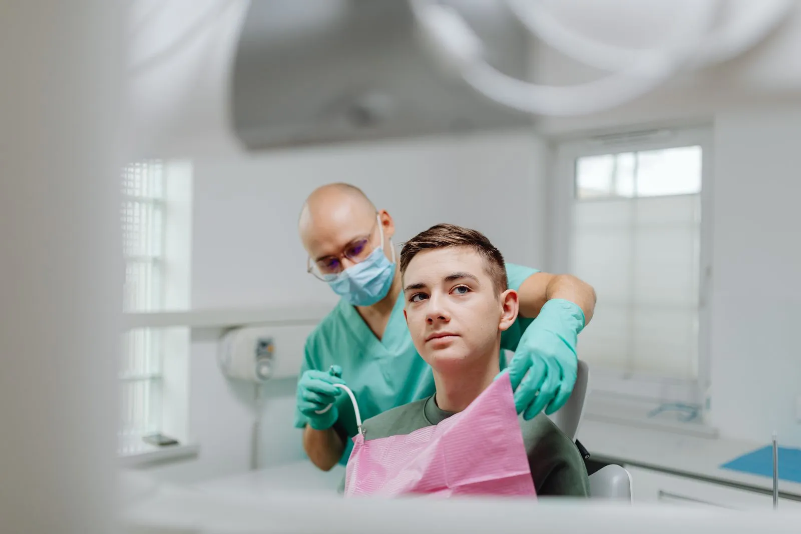 Dentist and teen patient in a modern clinic during a dental checkup.